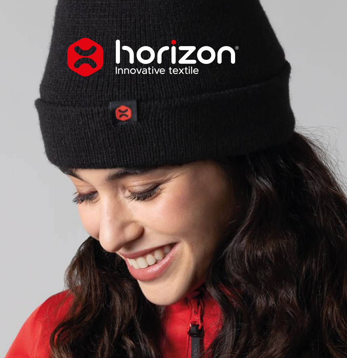 Horizon Innovative Textile : bonnet noir personnalisé porté par une femme souriante
